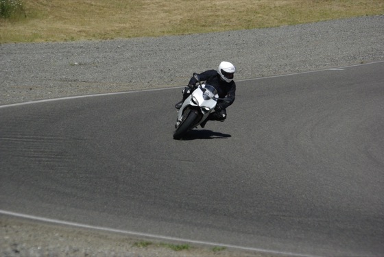 Jonathan cornering a white 2013 Ducati 1199 S on track in black leathers