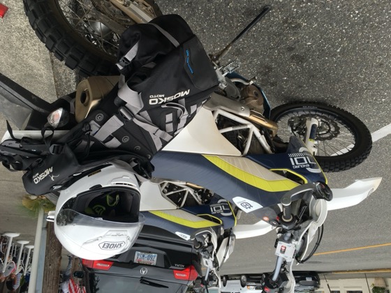 Two Husqvarna 701 Enduro bikes with Mosko Moto luggage parked on a small-town street