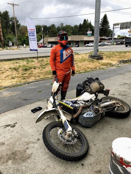 Jonathan standing beside his 2016 Husqvarna 701 Enduro laid over on a sidewalk