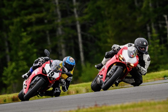 Jonathan leading Kayla Yaakov, both on Ducati Panigales, through a corner at a track day