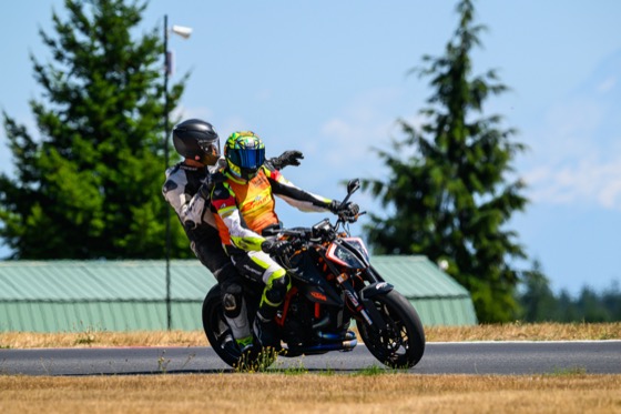 Garrick giving Jonathan a two-up ride back on his Super Duke after a crash at Turn 6 at The Ridge