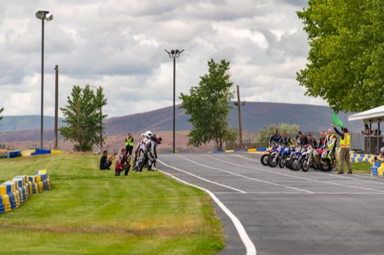 The flagger waving the green flag as riders run to their bikes (photo 5 of 77)