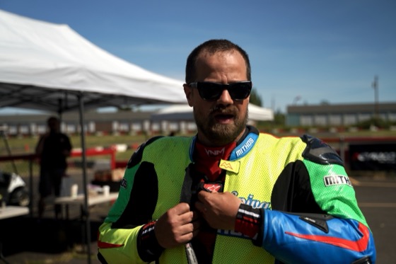 Jonathan Spiva in the paddock in Spiva Mithos leathers, helmet under his arm