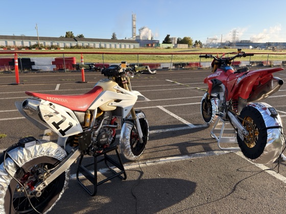 The Honda CRF150R (#711) and the Ducati Desmo450 on stands with tire warmers in the Mac Track paddock (photo 1 of 7)