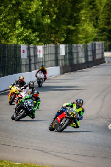 Jonathan Spiva (#916) leading a group of riders through a corner at PIR