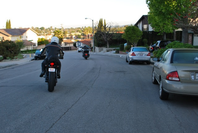Two riders heading away down a suburban California street