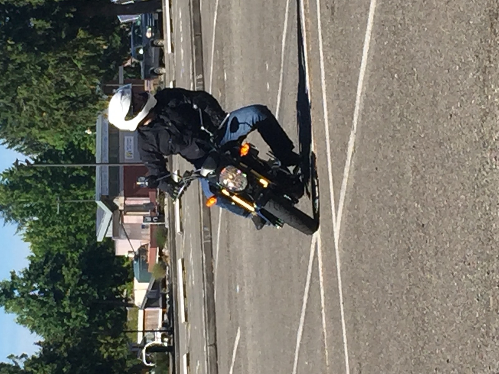 Jonathan riding a Honda Grom in an empty parking lot in jeans and a jacket