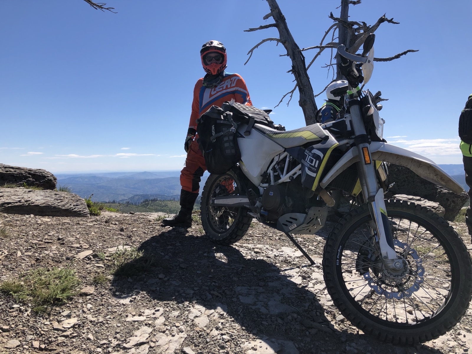 Jonathan standing next to the 2016 Husqvarna 701 Enduro at a rocky mountain overlook in orange dual-sport gear
