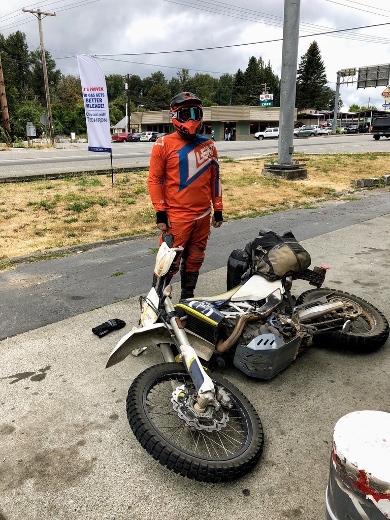Jonathan standing beside his 2016 Husqvarna 701 Enduro laid over on a sidewalk