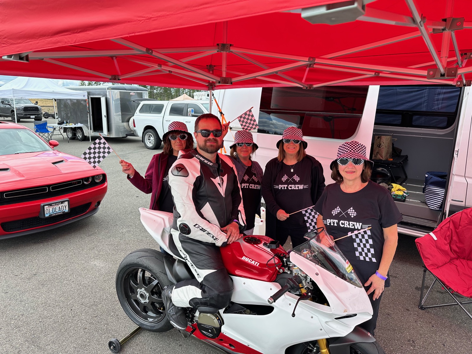 Jonathan's mom and aunts in matching Pit Crew shirts around the Ducati Panigale at a track day