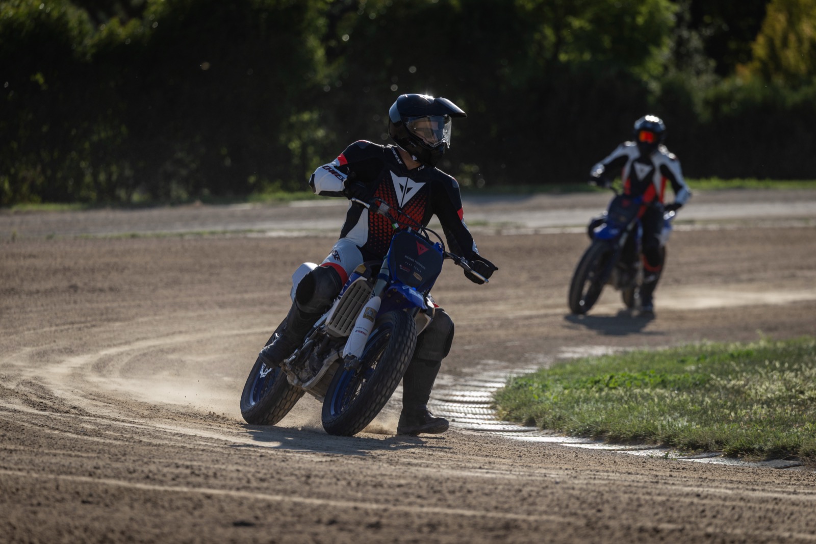 Jonathan sliding a flat track bike, foot out, at Valentino Rossi's Motor Ranch in Italy