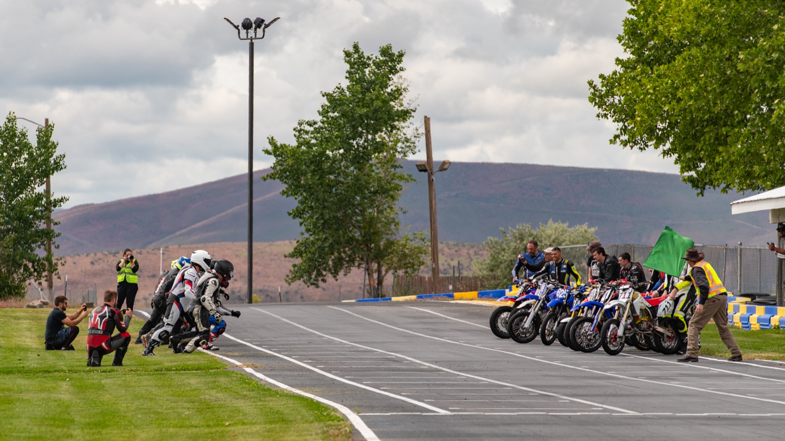 Riders running to their bikes under the green flag (photo 6 of 77)