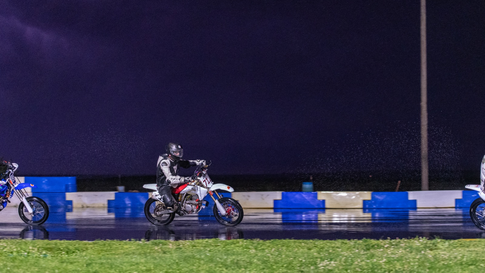 Jonathan Spiva on the #711, reflected in the wet track under a storm sky (photo 68 of 77)