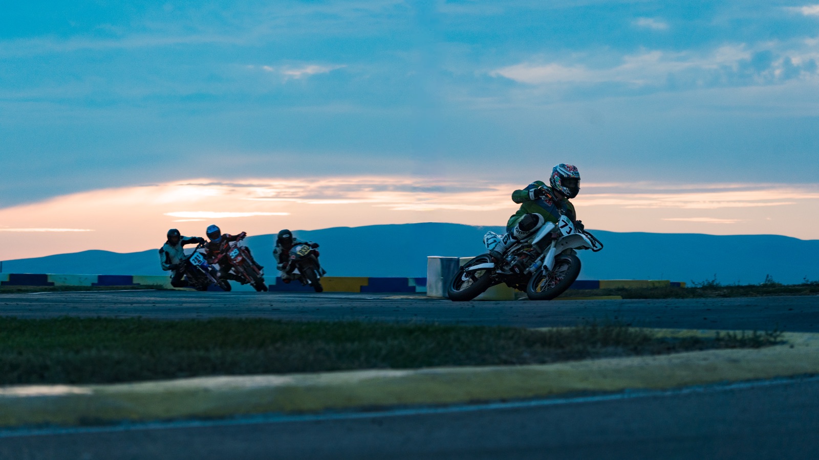 The #711 ahead of a group of riders as the light fades (photo 49 of 117)