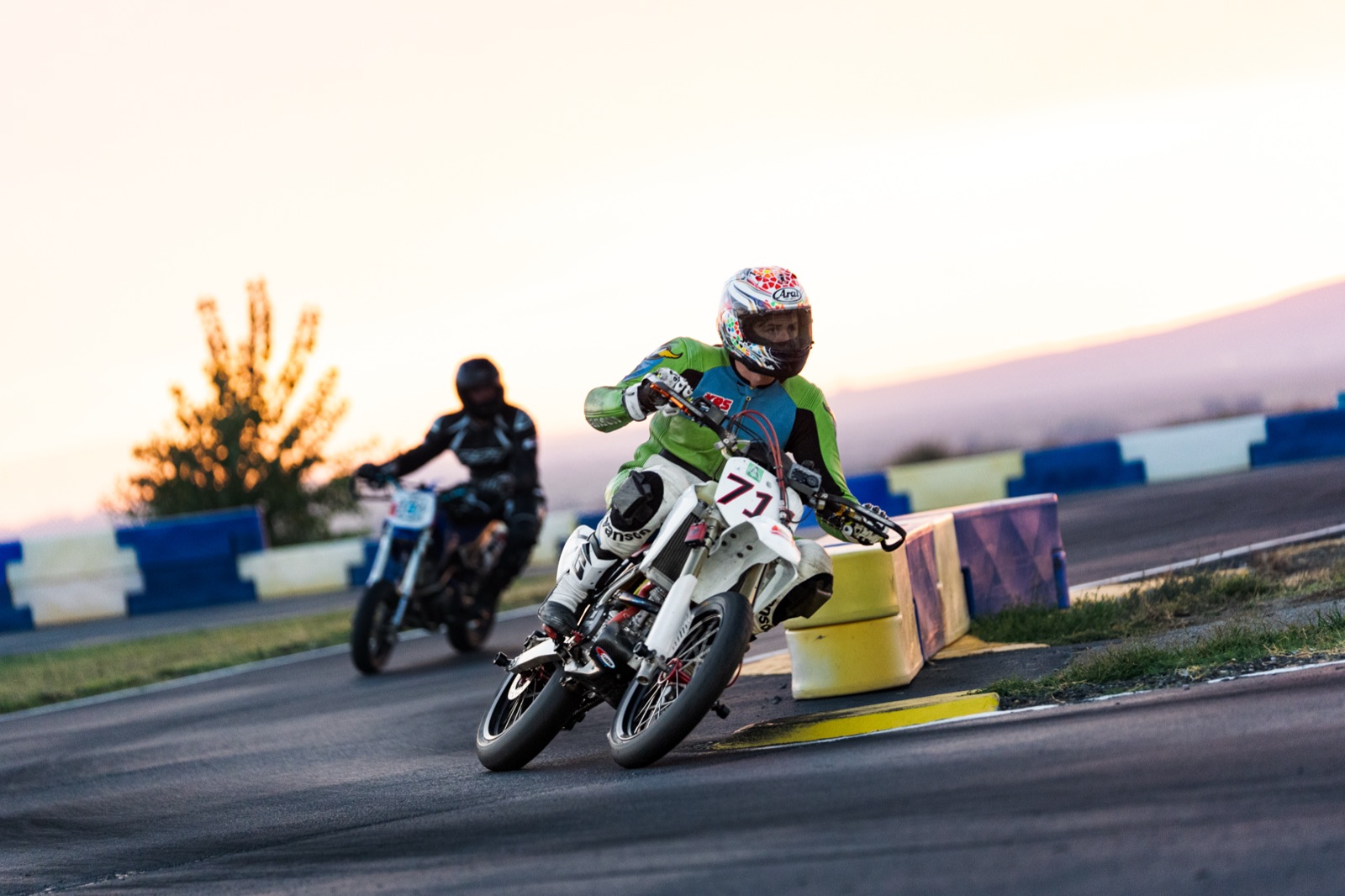 John Gessner on the #711 leading another rider through a corner at sunset (photo 61 of 117)