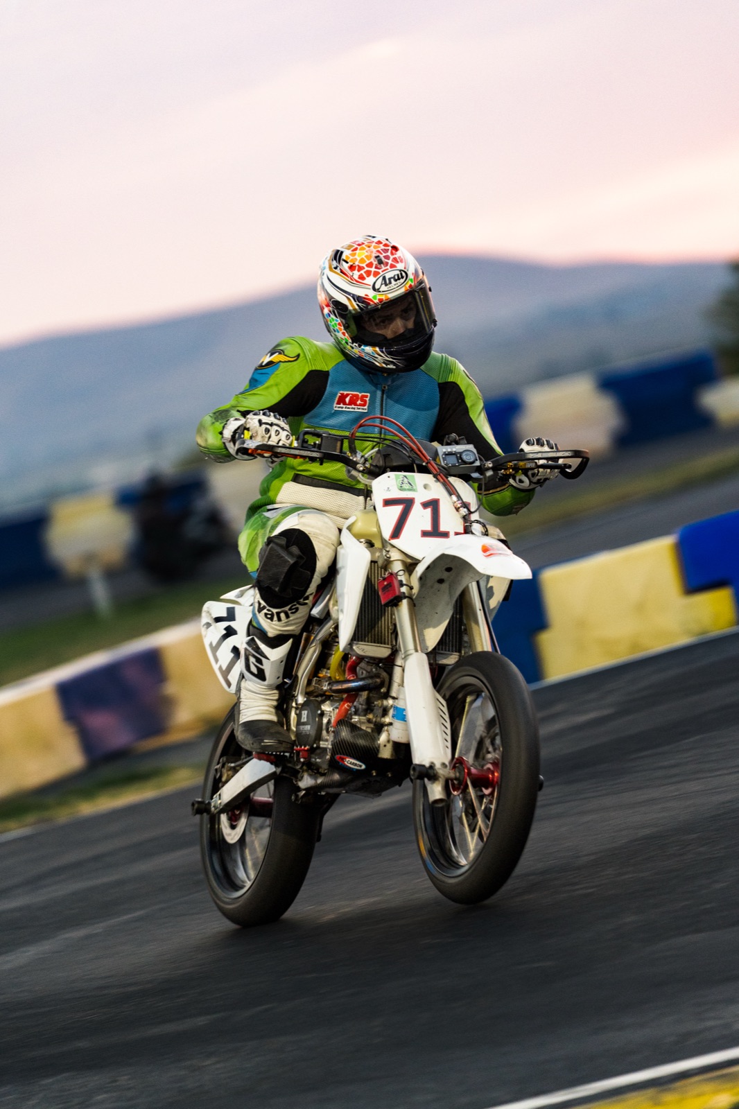 Head-on view of John Gessner on the #711 coming out of a corner at dusk (photo 65 of 117)