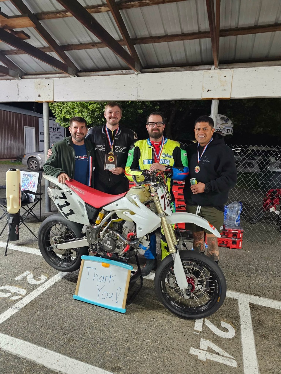 The Spiva Racing Team with their medals and the Honda CRF150R #711