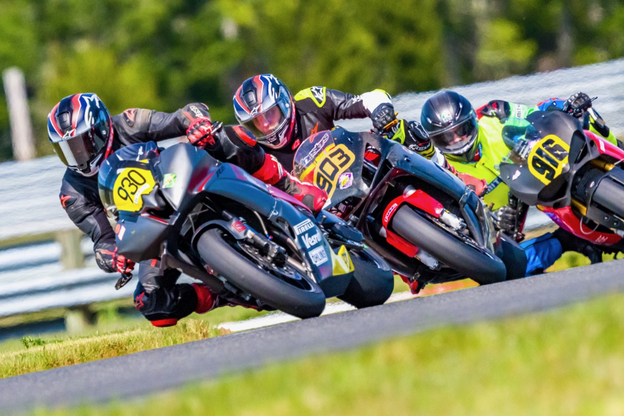 Jonathan Spiva (#916) in a pack of riders cornering at The Ridge