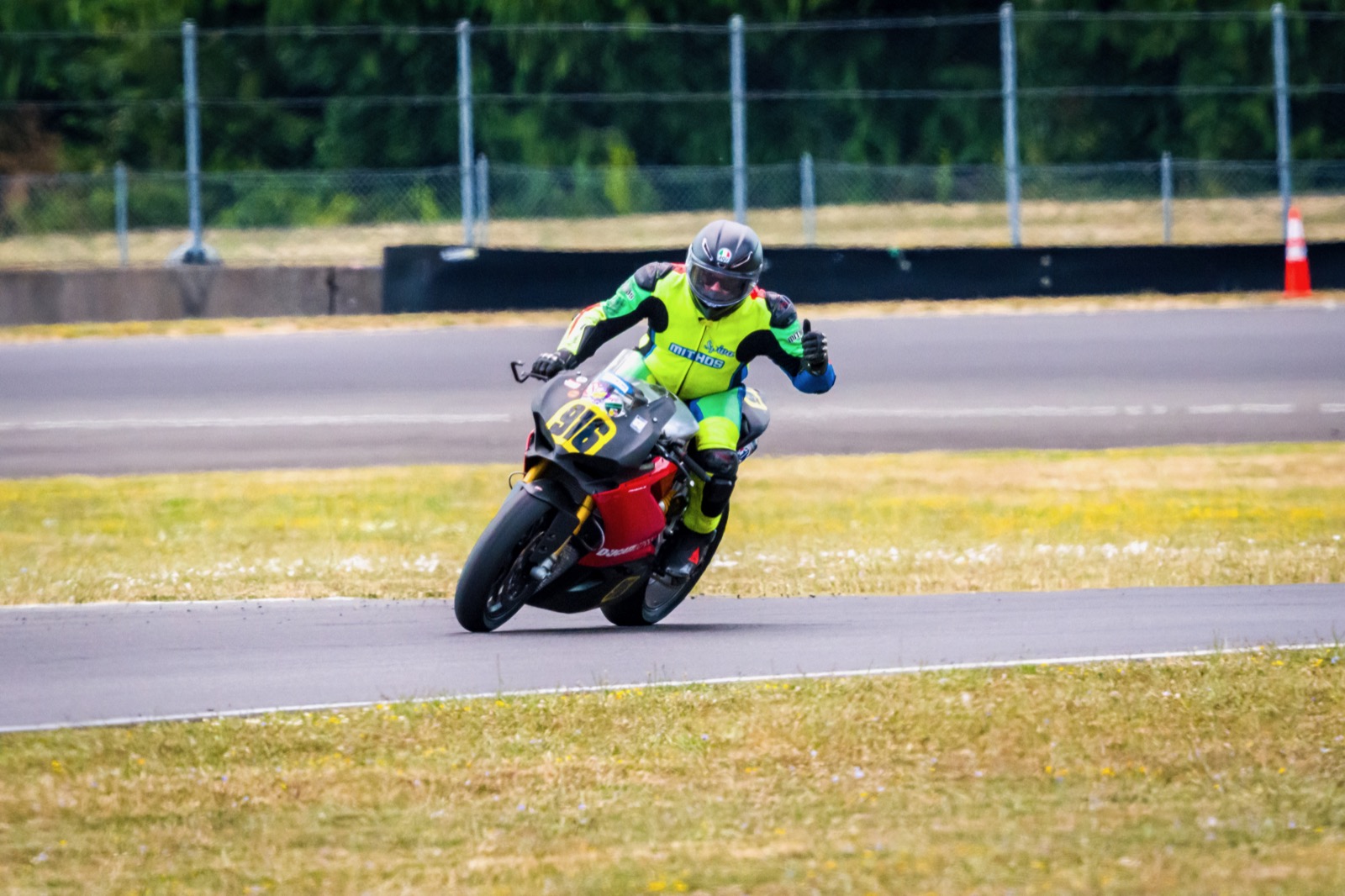 Jonathan Spiva sitting up with a hand raised on the #916 Panigale R at Portland International Raceway