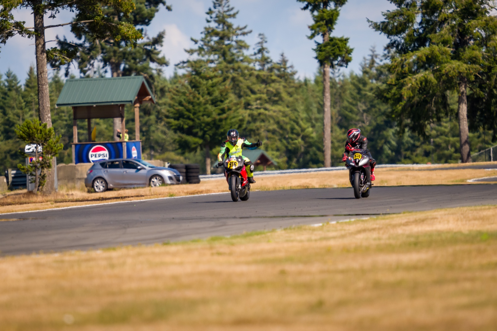 Jonathan Spiva (#916) and Steve Schock (#930) upright with thumbs up on the cool-down lap at The Ridge Motorsports Park